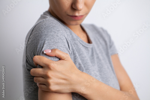 Arm pain woman suffering from sholder pain on gray background