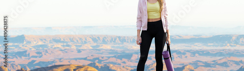 A thin athletic girl takes a break between classes on the background of mountains in the early morning