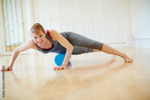 Taking care of her body through yoga. Shot of a woman doing roller foam exercises during a yoga workout.