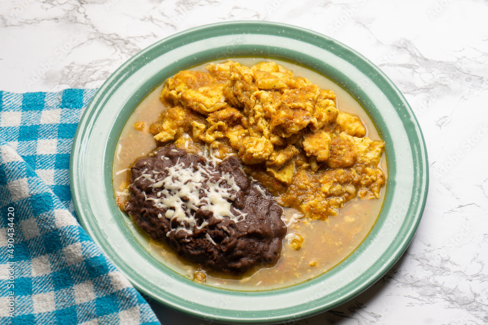 Scrambled eggs with red sauce and beans. Mexican food Scrambled eggs with red sauce and beans. Mexican food