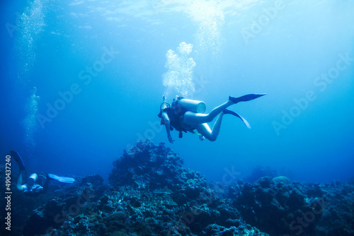 Exploring the oceans endless wonders. Two scuba divers explore a rocky reef - Copyspace.