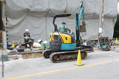 道路工事をしているショベルカーと作業員