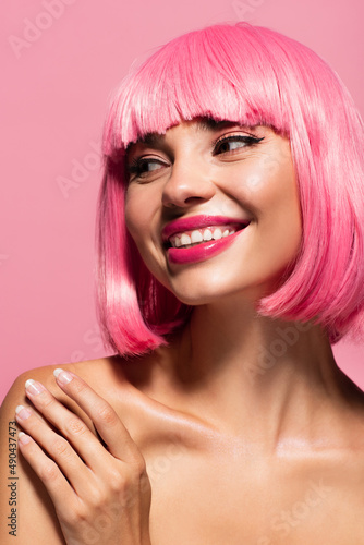 happy young woman with colored hair looking away isolated on pink.