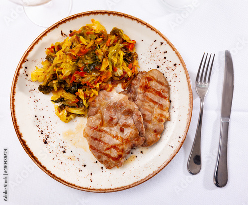 German dish, grilled pork chop garnished with stewed cabbage in a restaurant