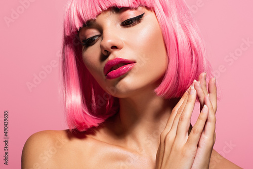 close up of young woman with bangs and colored hair isolated on pink.