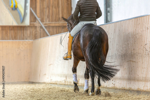 Fotografía A rider in training with a dressage horse in a riding hall