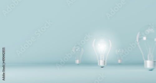 Light bulb bright outstanding among lightbulb on light blue background. Concept of creative idea and innovation, Unique, Think different, Individual and standing out from the crowd. 3d illustration