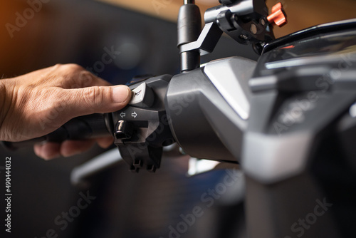 rider holding handlebar and pressing the horn button on motorcycle,repair motorcycle concept in garage.selective focus