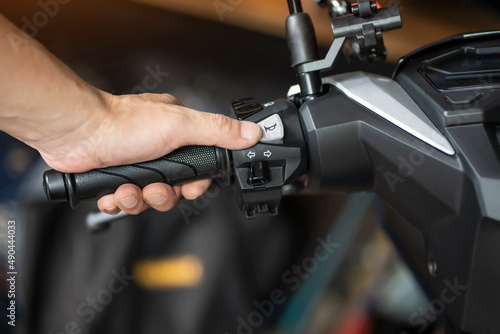 Obraz na płótnie rider holding handlebar and pressing the horn button on motorcycle, repair motorcycle concept in garage.selective focus w salonie