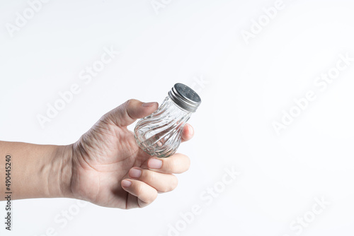 Hand holding seasoning bottle with stainless steel cap