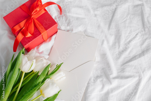 Tulips flowers, red gift box and empty card for text. Mock-up. Concept of womans day, mothers day