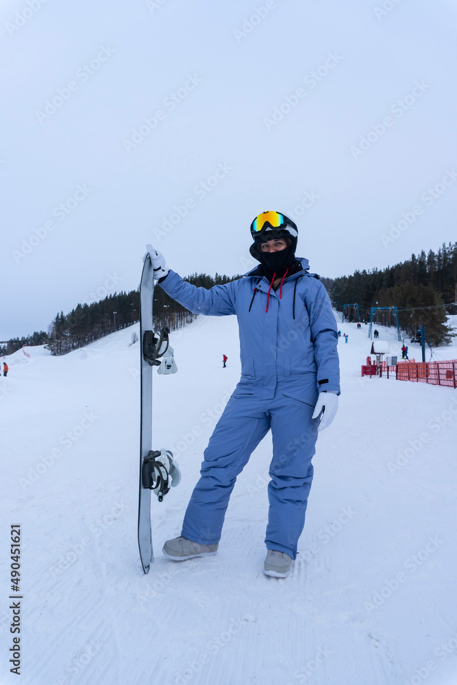photo of young woman with snowboard at ski resort