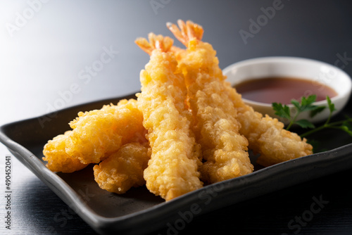 Obraz na plátně Shrimp tempura on a plate placed against a black background.