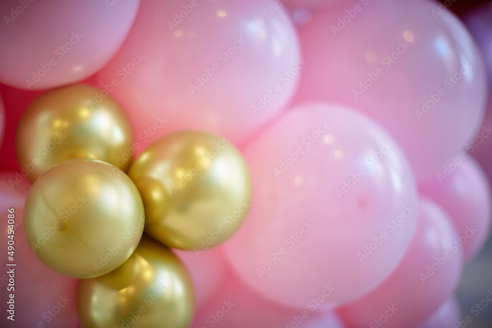 many pink and gold balloons forming a bright background wallpaper image. close-up.