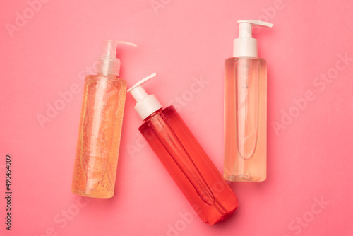 Bottles with gel for washing on a pink background. Care cosmetics. Copy space. Article about the choice of gel for washing.
