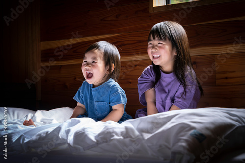 ベッドの上に座る日本人姉妹