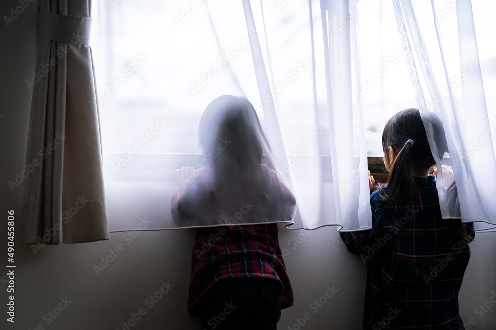 窓から外を眺める姉妹の後ろ姿 窓から外を眺める姉妹の後ろ姿