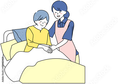 起き上がるシニアと介助をする介護士