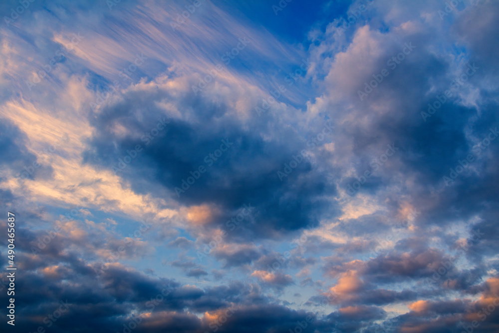 Amazing sunset cumulus and cirrus cloud on blue sky. Nature, climate background, toned photo