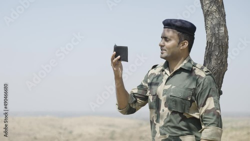 Soldier remebers his family by seeing photo from wallet during service - concept of family affection, bonding and happiness. photo