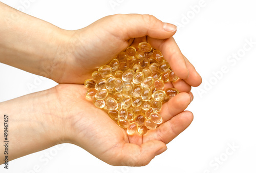 Vitamin capsules in the palms of a person on a white background. Dietary supplements: fish oil, omega-3, omega-6, omega-9, vitamin A, E, vitamin D, vitamin D3, evening primrose oil, borage.