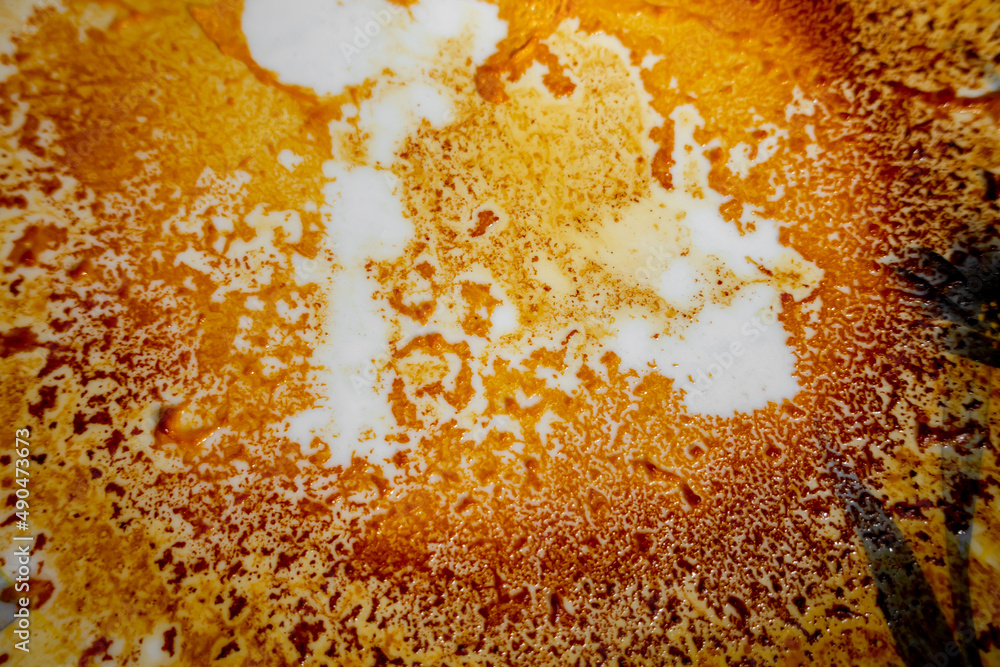 Abstract yellow-orange burning cream texture in white background. Milk burning pots orange-yellow texture. Abstract rustic texture. Abstract yellow-orange burning cream texture in white background. Milk burning pots orange-yellow texture. Abstract rustic texture.