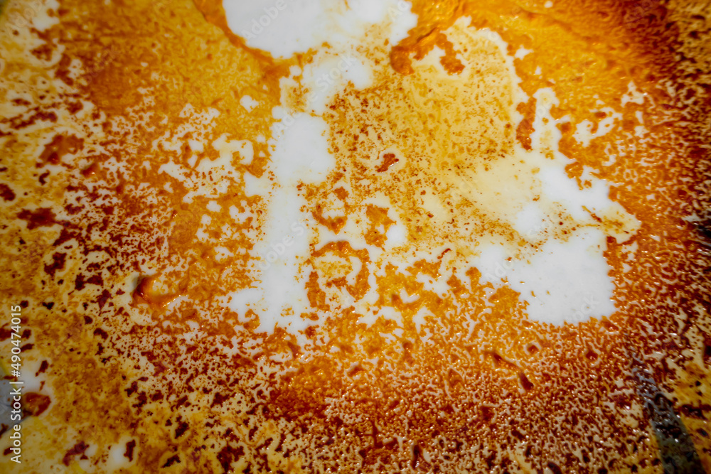 Abstract yellow-orange burning cream texture in white background. Milk burning pots orange-yellow texture. Abstract rustic texture. Abstract yellow-orange burning cream texture in white background. Milk burning pots orange-yellow texture. Abstract rustic texture.