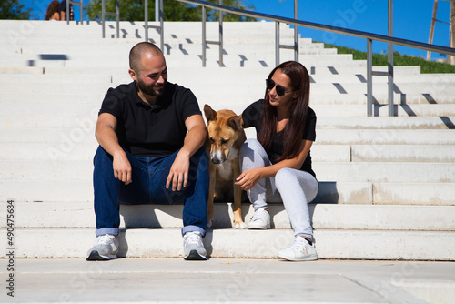 Foto Adult couple sitting on a park bench with their dog posing for a family photo