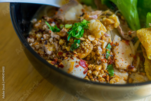 Closeup Spicy TOM YAM Pork Noodles Soup with Pork Balls, chilly pasted and lime juice 