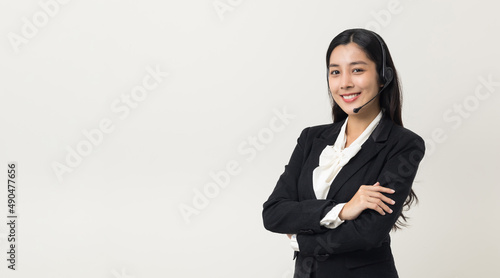 Happy young asian business woman call centre. Welcome female operator put on smalltalk headphone standing on isolated white background. photo