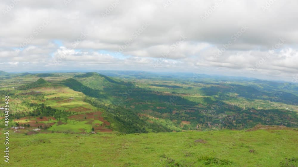 View of the valley as seen from the top of the hill during the Trek to Governer hill at Saputara in Gujarat, India. Clouds above the lush green valley of the Sahyadri mountain range. View of the valley as seen from the top of the hill during the Trek to Governer hill at Saputara in Gujarat, India. Clouds above the lush green valley of the Sahyadri mountain range.