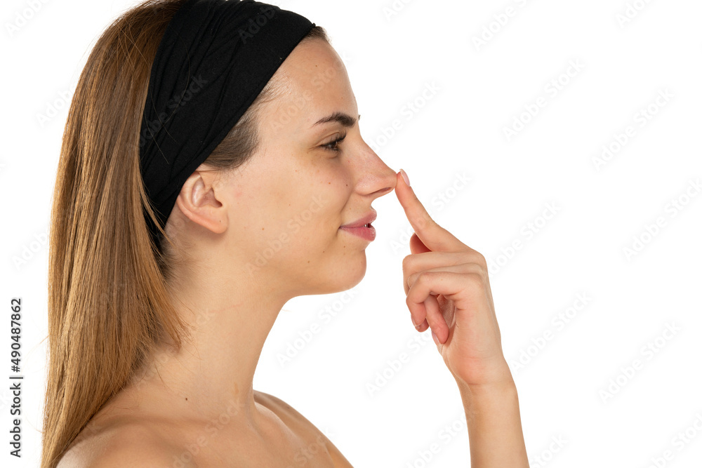 Young woman touching her nose with her finger Young woman touching her nose with her finger