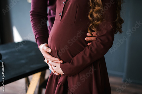 A man sits next to a pregnant woman and holds her stomach