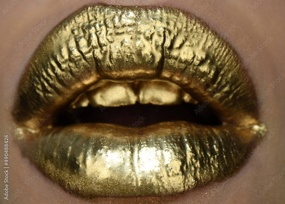 Obraz premium Golden lipstick closeup. Lips with metal makeup.
