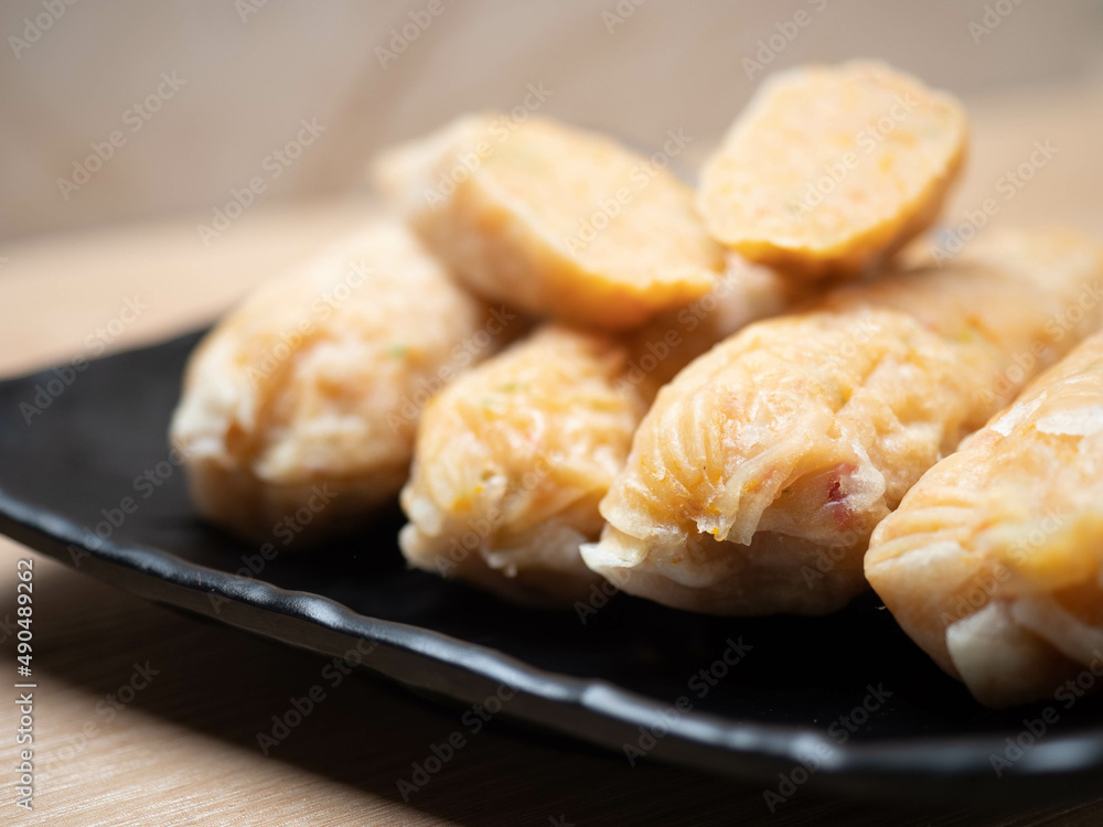 Stack of shrimp egg rolls on a black square bowl Stack of shrimp egg rolls on a black square bowl