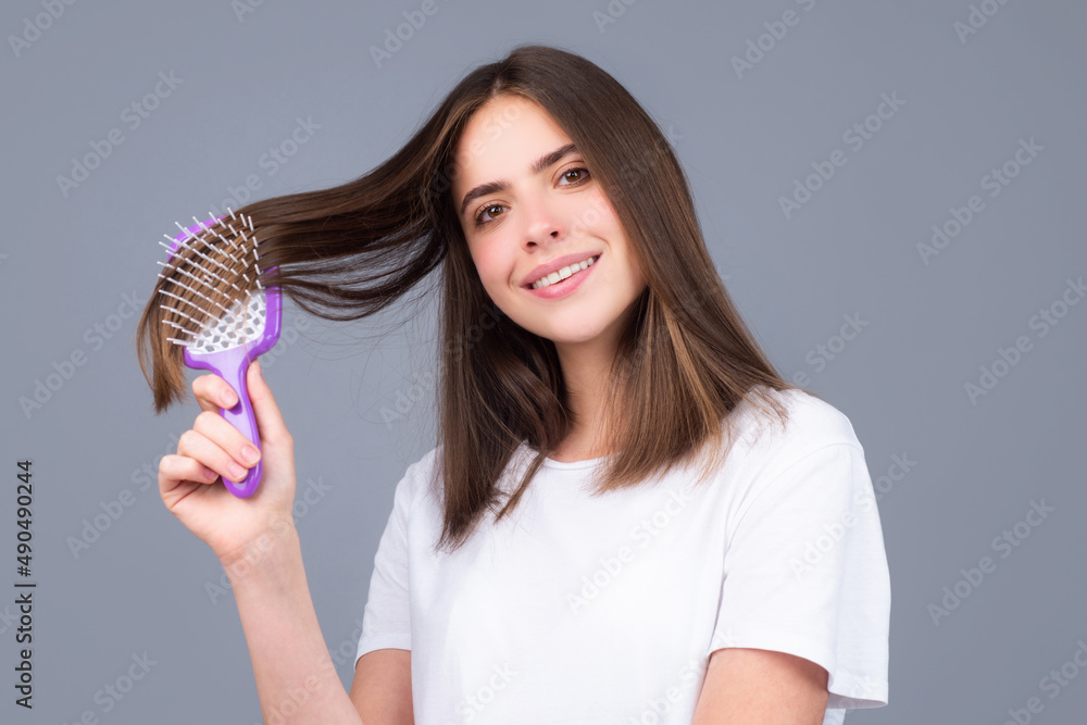 Beautiful woman combs her healthy hair. Combing healthy long straight female hair, close up. Beautiful woman combs her healthy hair. Combing healthy long straight female hair, close up.