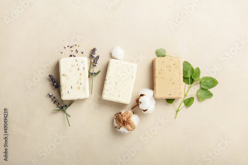 Natural soap bars and ingredients- lavender, cotton, patchouli - on natural stone background, flat lay photo