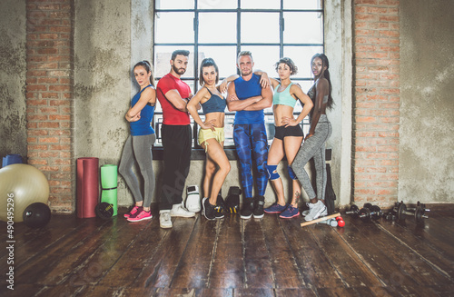 Group of young multiethnic people training and doing functional gymnastic in a New york design styled loft