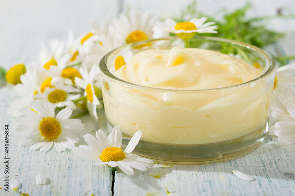 chamomile flowers and baby cream on faded white wooden table chamomile flowers and baby cream on faded white wooden table