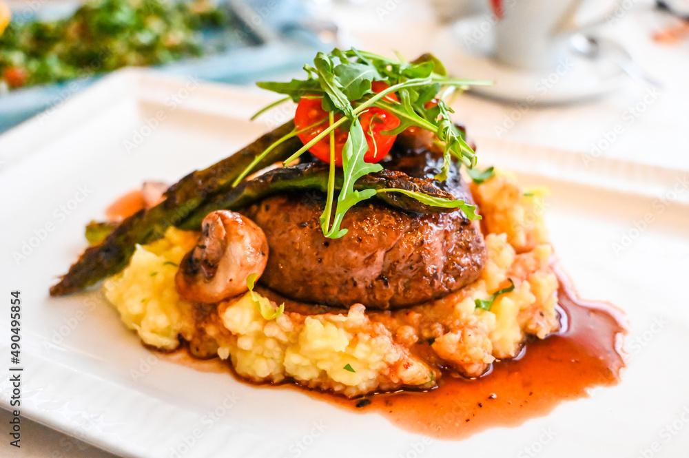 Beefsteak on plate. Roast meat in a restaurant. Delicious food. Grilled veal, close up.