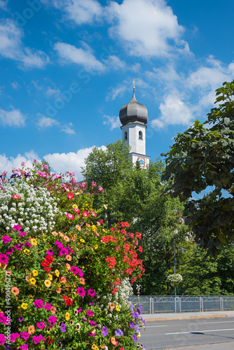 flower column beside the road, view to church tower. tourist resort Gmund