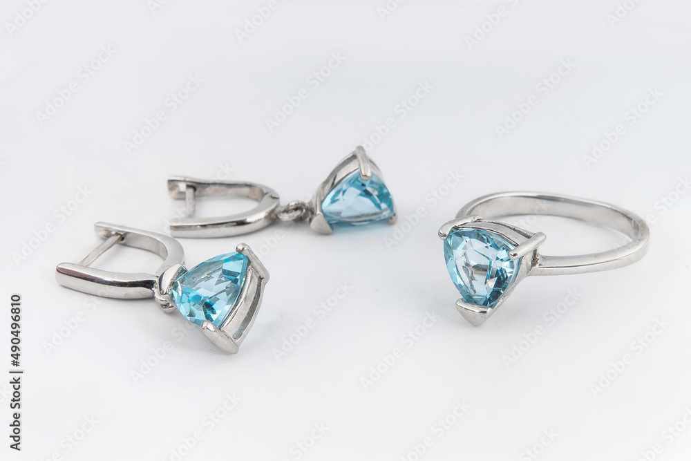 Elegant jewelry set of white gold ring, necklace and earrings with diamonds. Silver jewellery set with gemstones. Product still life concept Elegant jewelry set of white gold ring, necklace and earrings with diamonds. Silver jewellery set with gemstones. Product still life concept