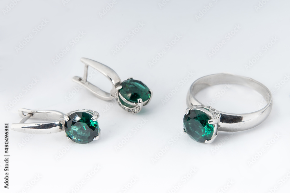 Elegant jewelry set of white gold ring, necklace and earrings with diamonds. Silver jewellery set with gemstones. Product still life concept Elegant jewelry set of white gold ring, necklace and earrings with diamonds. Silver jewellery set with gemstones. Product still life concept