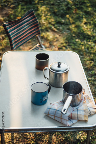 Fototapeta Naklejka Na Ścianę i Meble -  Two Mugs With Hot Drinks On The Table With Other Camping Equipment