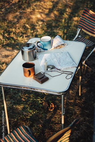 Fototapeta Naklejka Na Ścianę i Meble -  Two Mugs With Hot Drinks On The Table With Other Camping Equipment