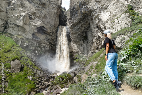 A girl at the Sultan-su waterfall surrounded by the Caucasus Mountains near Elbrus  Jily-su  Russia