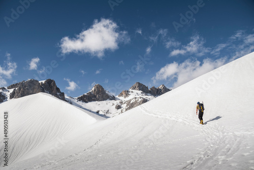 Hiker walks in the middle of a snow slope