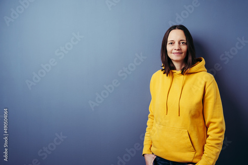 Image of a woman posing isolated over blue wall background. © contrastwerkstatt