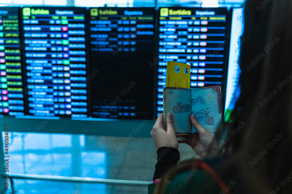 woman at the airport looking at the screens for her flight