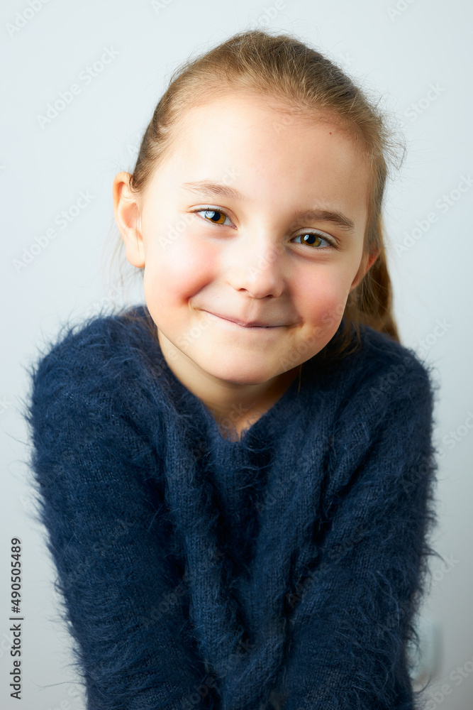 Portrait of adorable little girl. Cute small child looking at camera. Portrait of girl wearing blue sweater Portrait of adorable little girl. Cute small child looking at camera. Portrait of girl wearing blue sweater